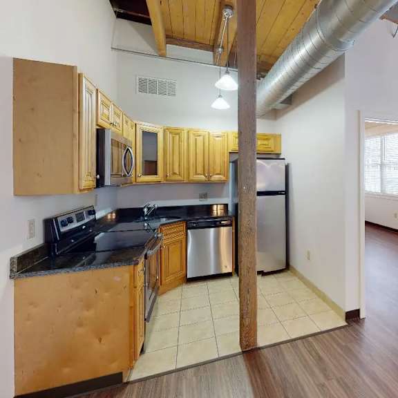 a kitchen with wooden cabinets and a stainless steel refrigerator.