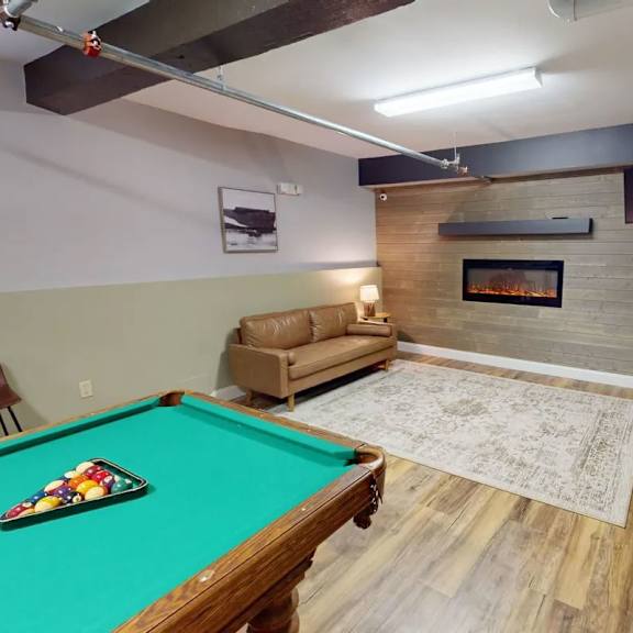 a pool table with a green cloth and a billiard cue.