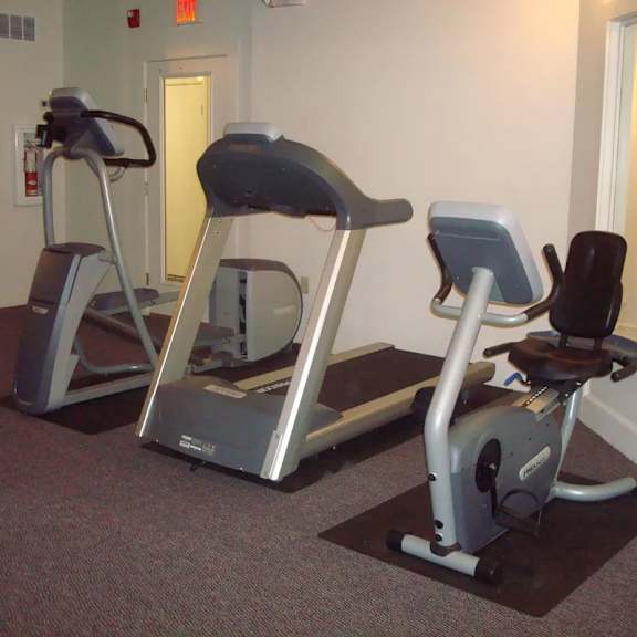 two exercise bikes are in a room.