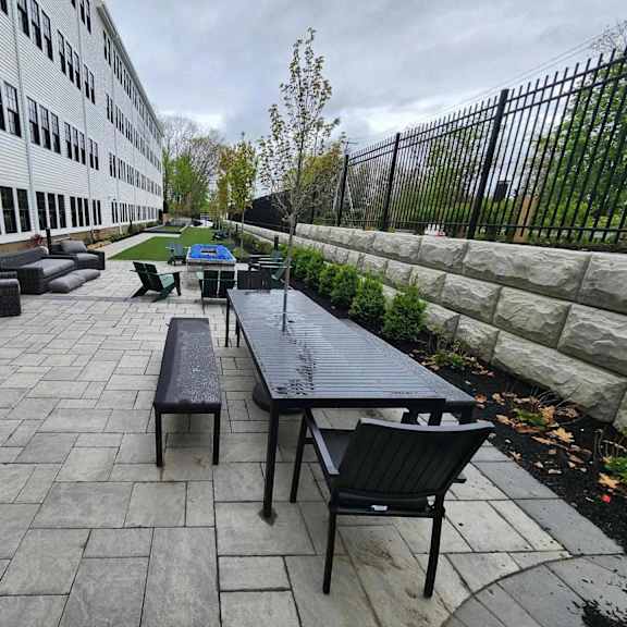 a patio with a table and chairs is in front of a building.