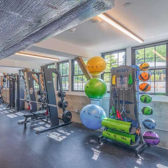 a gym with a variety of equipment including weights and exercise balls.