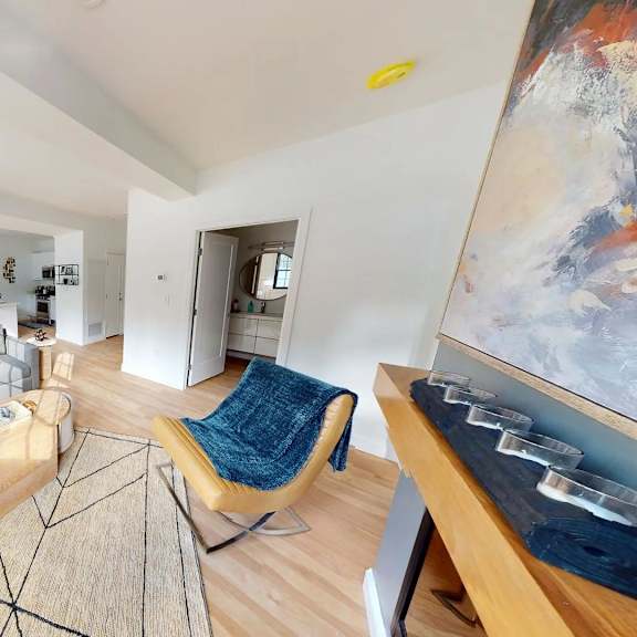 a living room with a large painting on the wall and a rug on the floor.