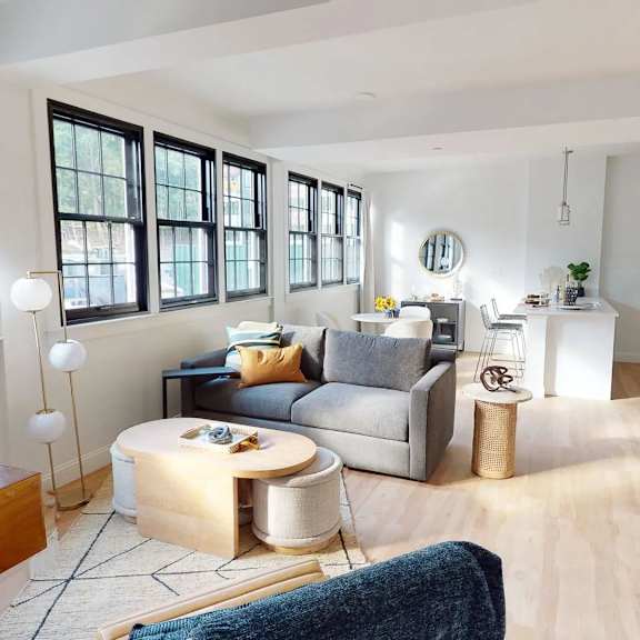 a living room with a couch, a coffee table, and a lamp.