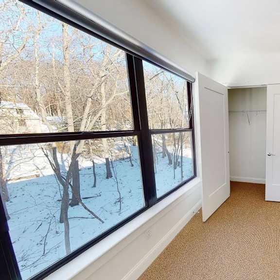 a room with a large window showing a snowy landscape outside.