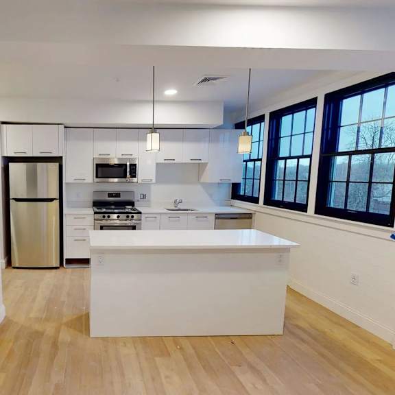 a kitchen with white cabinets and a white island.