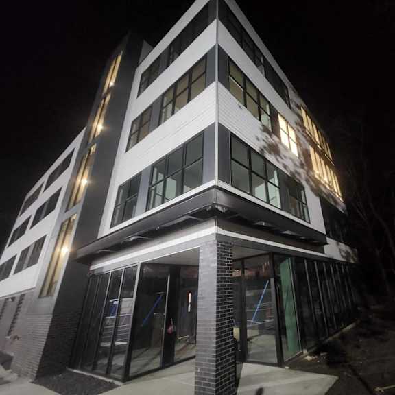 a modern building with a black and white facade is illuminated at night.