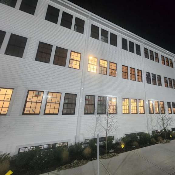 a white building with windows lit up at night.