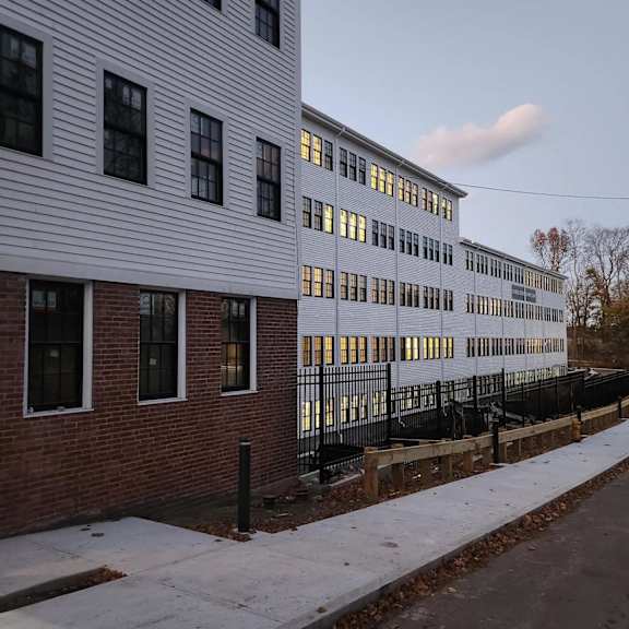a long white building with a black fence in front of it.