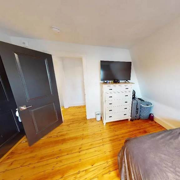 a room with a bed, a wardrobe, and a tv.