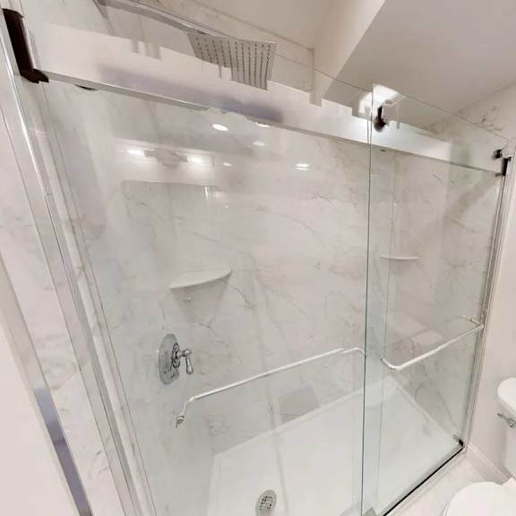 a white bathroom with a glass shower stall.