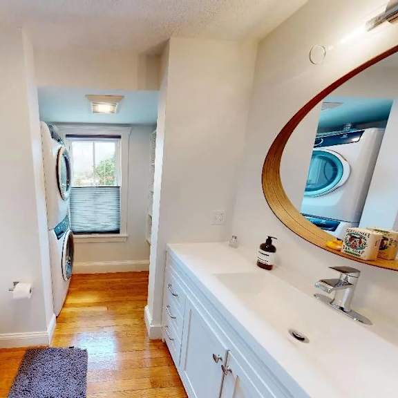 a bathroom with a toilet, sink, and mirror.