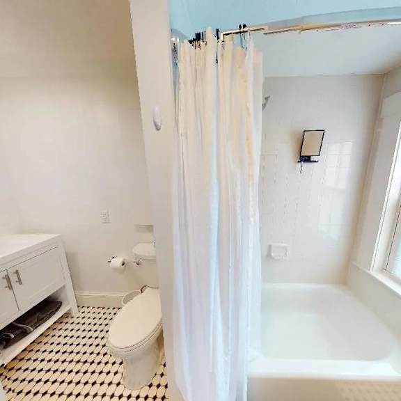 a white bathroom with a toilet, sink, and bathtub.