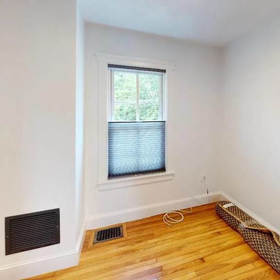 a room with a window and a vent on the wall.