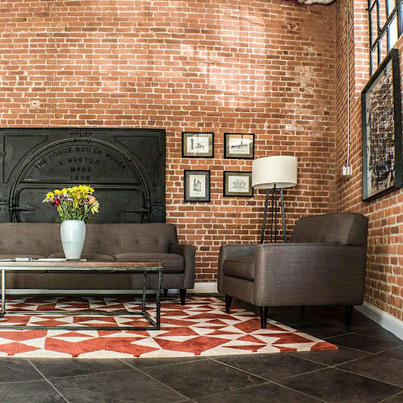 a living room with a brick wall and a fireplace.