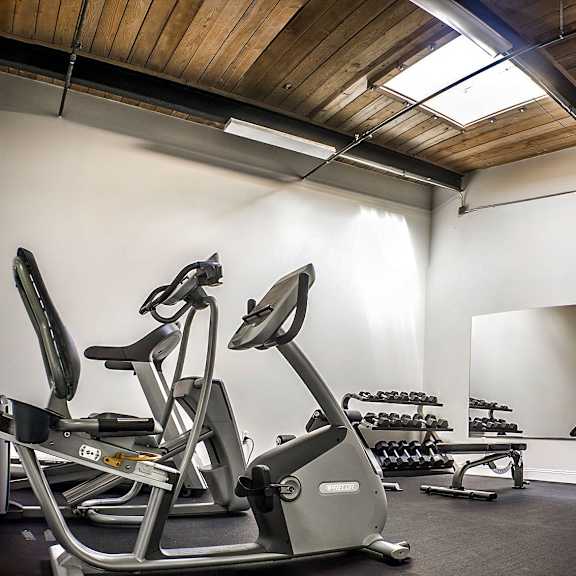 a gym with a wooden ceiling and a television mounted on the wall.