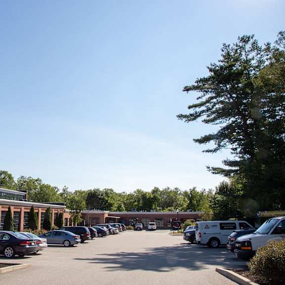 a parking lot with cars and a building in the background.