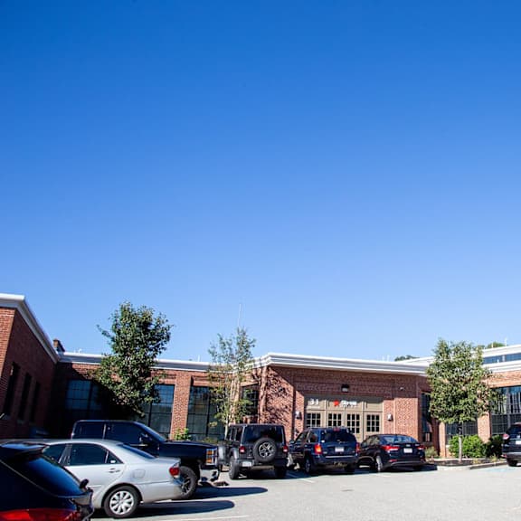 a parking lot with cars and a building in the background.