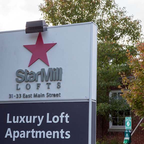 a sign for starville lofts is displayed in front of a tree.