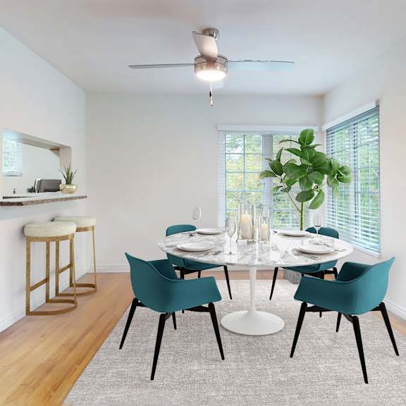 a dining room with a white table and blue chairs at sunset barrington gardens, los angeles, 90049