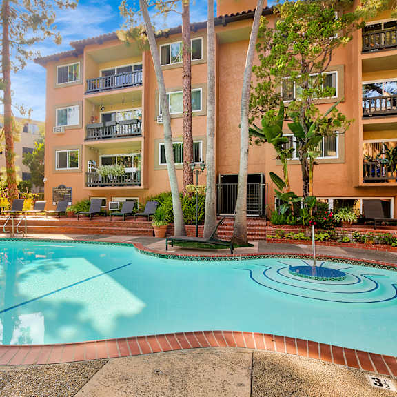 a large swimming pool in front of a multi-story apartment building at casa granada, los angeles, 90049