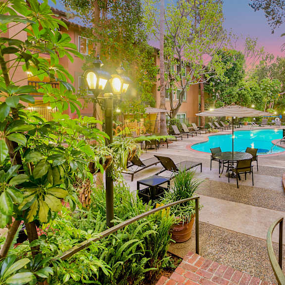 a backyard with a swimming pool and a patio with tables and chairs at casa granada, los angeles, ca, 90049