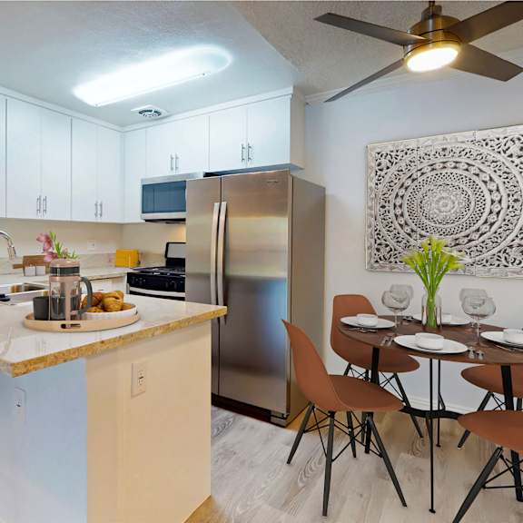 a kitchen with a breakfast bar and a stainless steel refrigerator at casa granada, los angeles, 90049