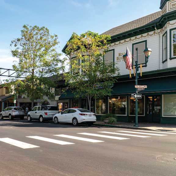 a city street with cars parked in front of a restaurant at pleasanton place, california, 94566