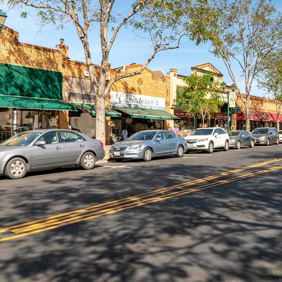a row of cars parked on the side of a street  at pleasanton place, pleasanton, ca, 94566
