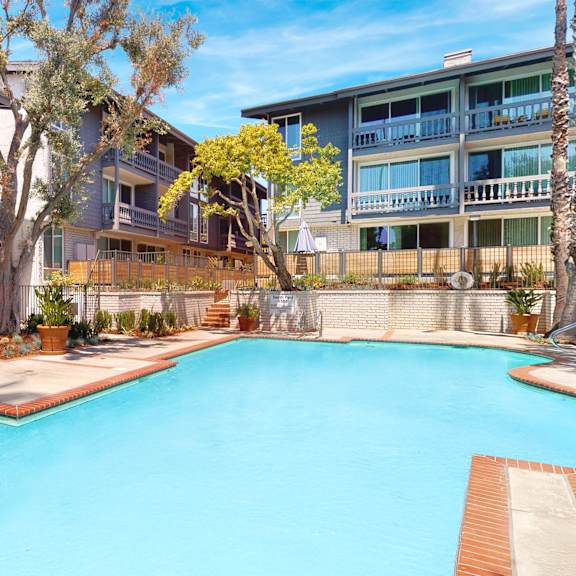 a swimming pool in front of apartment buildings at the meadows apartments, culver city , ca 90230