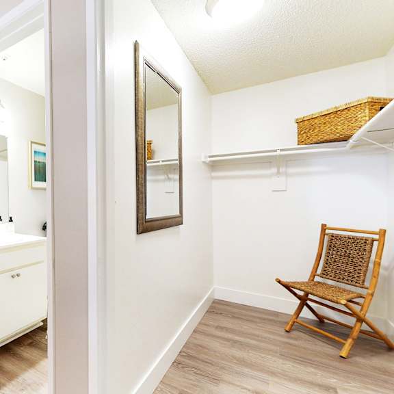a white bathroom with a wooden chair and a mirror at mountain vista, victorville, ca