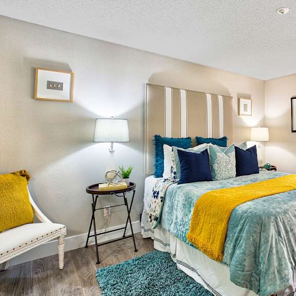 a bedroom with a bed, nightstand, and a chair at mountain vista, victorville, ca