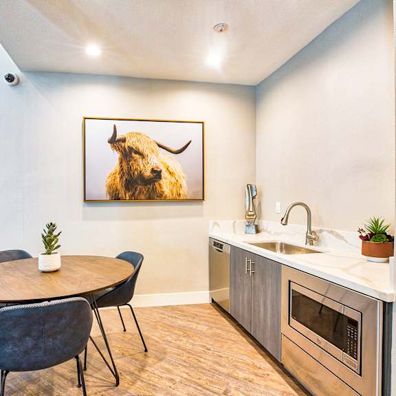 a kitchen with a table and chairs and a painting of a bison on the wall at mountain vista, victorville, ca