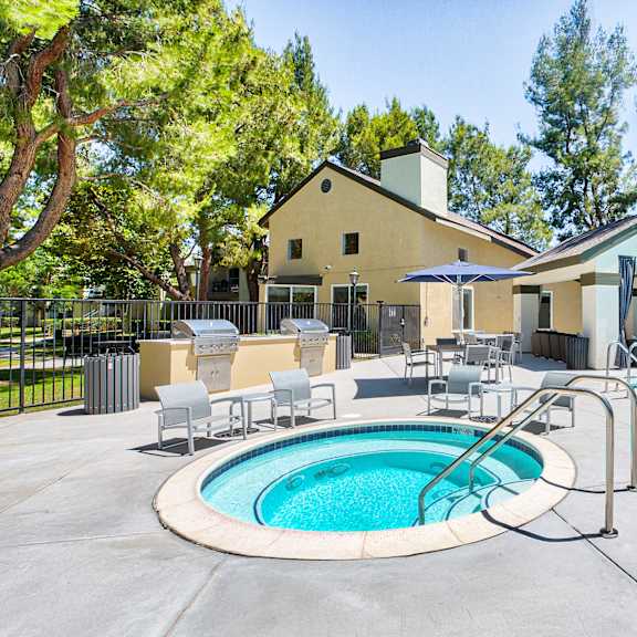 a pool with a hot tub and a house in the background at mountain vista, victorville, ca