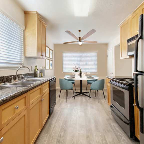 a kitchen with wooden cabinets and a black refrigerator at pleasanton place, pleasanton, ca, 94566