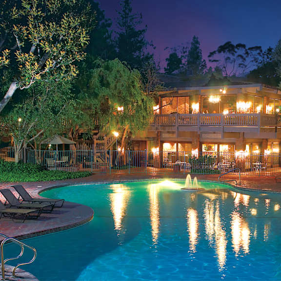 a large swimming pool in front of a lit building at night at the meadows apartments, culver city , ca 90230