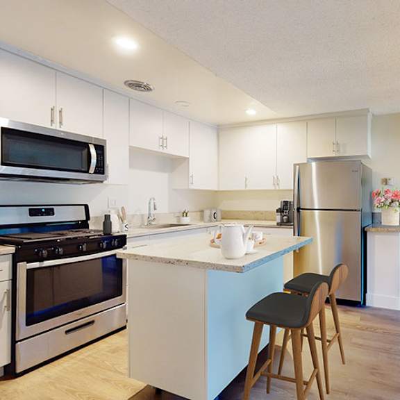 a kitchen with white cabinets and a blue island at mediterranean village west hollywood, west hollywood, 90069