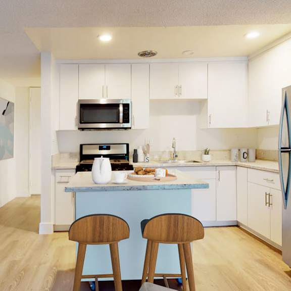 a kitchen with a blue island and stainless steel appliances at mediterranean village west hollywood, west hollywood, 90069