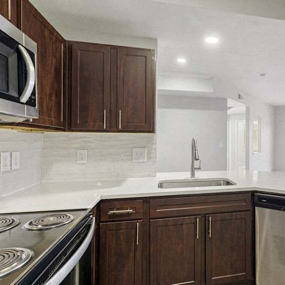 Thumbnail 3 of 10 a kitchen with wooden cabinets and a sink and a dishwasher at The Legends at Eagle Mountain Lake, Texas, 76179