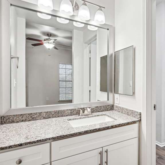 Thumbnail 9 of 16 A bathroom with a white sink and a glass shower.