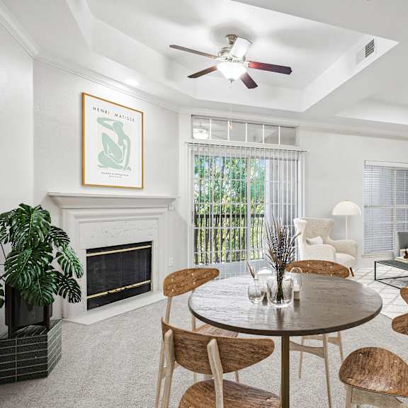 Thumbnail 4 of 16 a living room with a table and chairs and a fireplace at La Ventura Apartments, Plano, TX, 75093