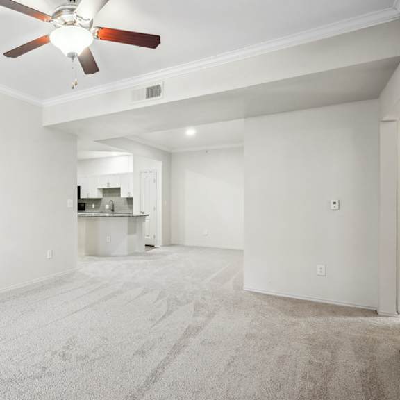 Thumbnail 12 of 16 A room with a ceiling fan and carpeted floor.