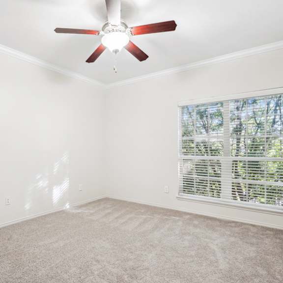 Thumbnail 13 of 16 A room with a ceiling fan and a window with blinds.