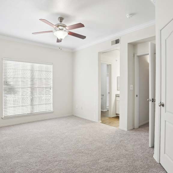 Thumbnail 14 of 16 A room with a ceiling fan and a window with blinds.