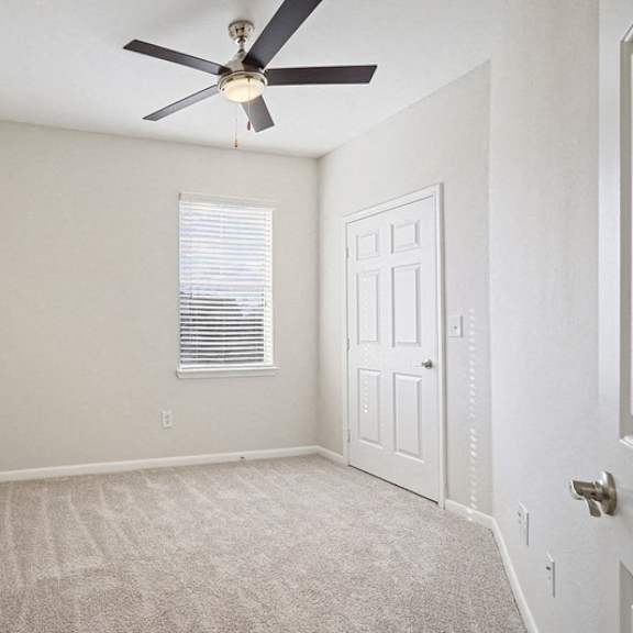 Thumbnail 9 of 10 an empty room with a ceiling fan and a white door at The Legends at Eagle Mountain Lake, Fort Worth, TX, 76179