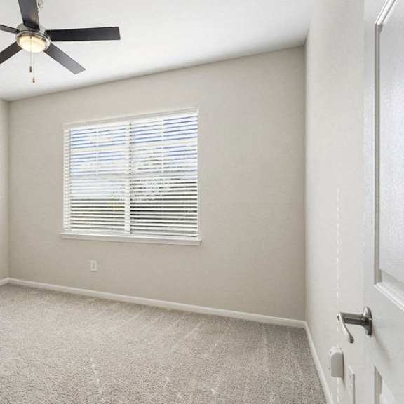 Thumbnail 8 of 10 an empty room with a ceiling fan and a window at The Legends at Eagle Mountain Lake, Fort Worth, 76179