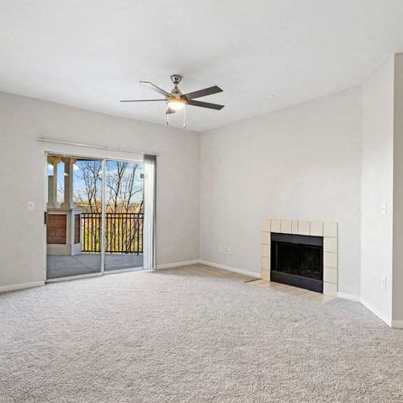Thumbnail 6 of 10 an empty living room with a fireplace and a ceiling fan at The Legends at Eagle Mountain Lake, Fort Worth, TX