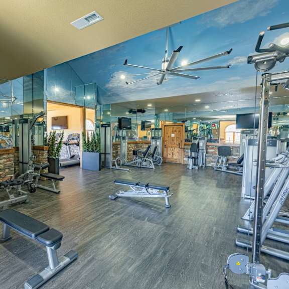 A gym with a variety of equipment including treadmills, weights, and exercise machines.