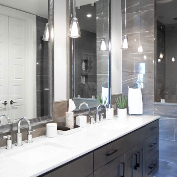 3 bedroom model master bathroom with two sinks and a walk-in shower