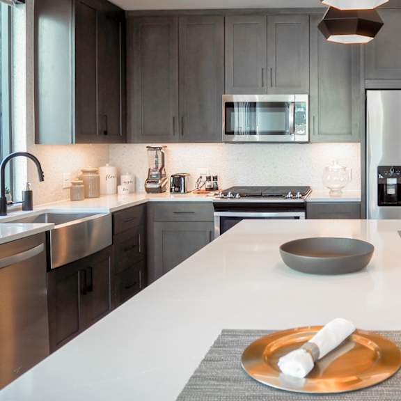 3 bedroom model kitchen with a white quartz counter top and a stainless steel appliances at the hamilton apartments in dallas, tx