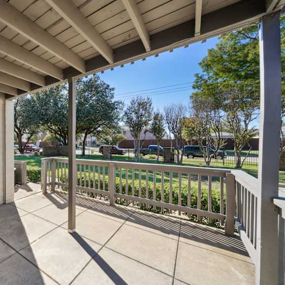 a view to the green area from the covered porch at woodlands of plano in plano, tx